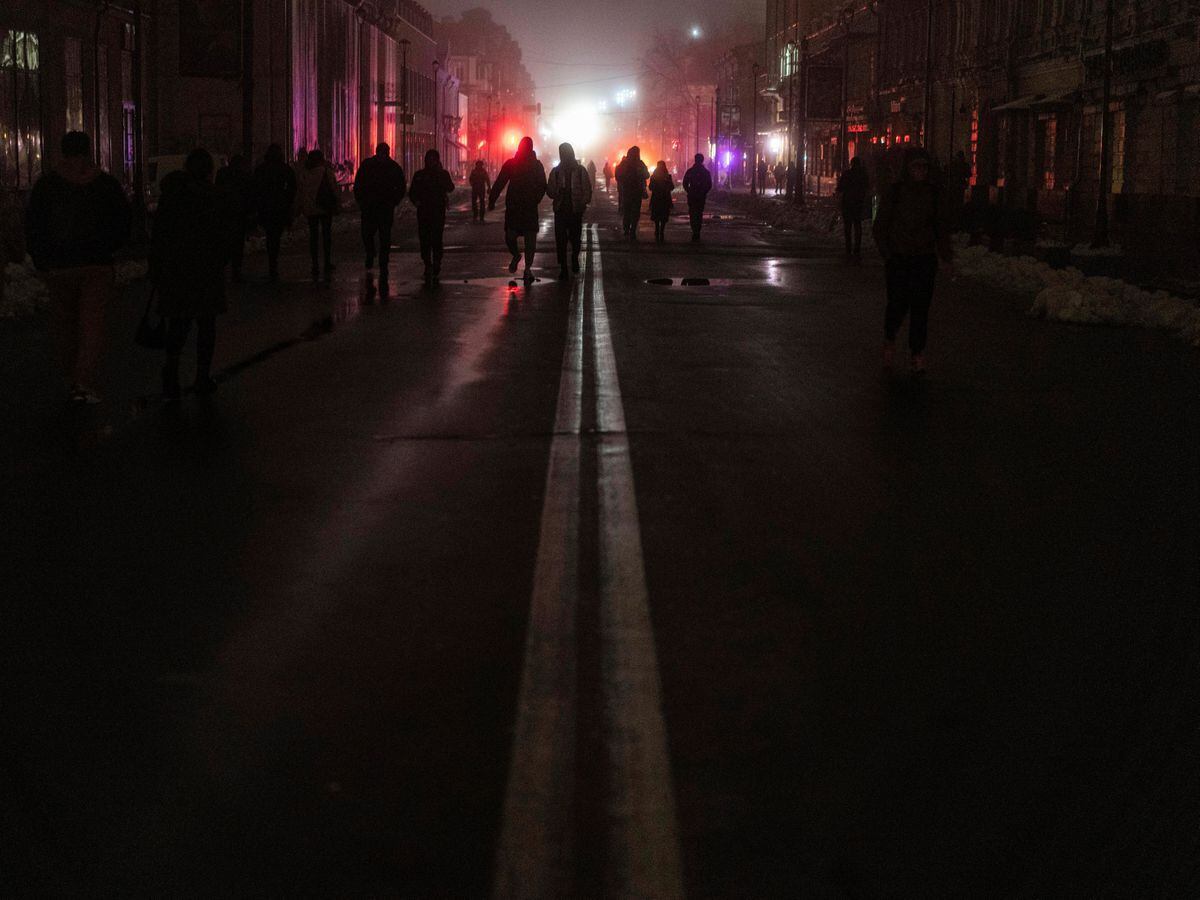 People walk in the city center where power was cut off yesterday after a Russian rocket attack in Kyiv, Ukraine