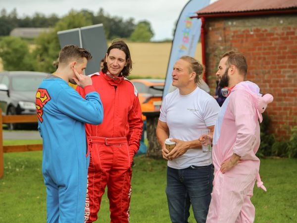 James Phelps, in red, chats to fellow wing walkers. Photo by Neil Tung.