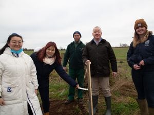 Professor Ken Sloan (centre) plants a tree with Harper Adams staff and students looking on