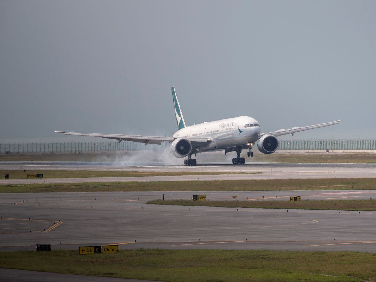 A Cathay Pacific airplane lands on the new third runway at Hong Kong International Airport