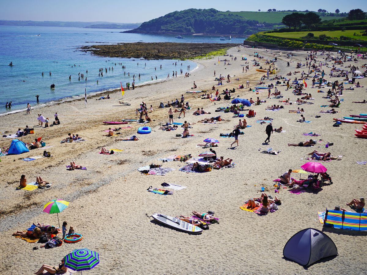 People enjoy the sunshine on Gyllyngvase Beach near Falmouth in Cornwall