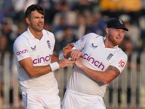 England's James Anderson, center, and Ben Stokes celebrate after the dismissal of Pakistan's Zahid Mahmood during the fifth day of the first test cricket match between Pakistan and England, in Rawalpindi, Pakistan, Monday, Dec. 5, 2022. (AP Photo/Anjum Naveed).