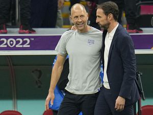 Head coach Gregg Berhalter of the United States and England's head coach Gareth Southgate talk at the end of the World Cup group B soccer match between England and The United States, at the Al Bayt Stadium in Al Khor , Qatar, Friday, Nov. 25, 2022. (AP Photo/Julio Cortez).