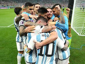 Lionel Messi, front, is embraced by his team-mates after setting up the third goal for Julian Alvarez