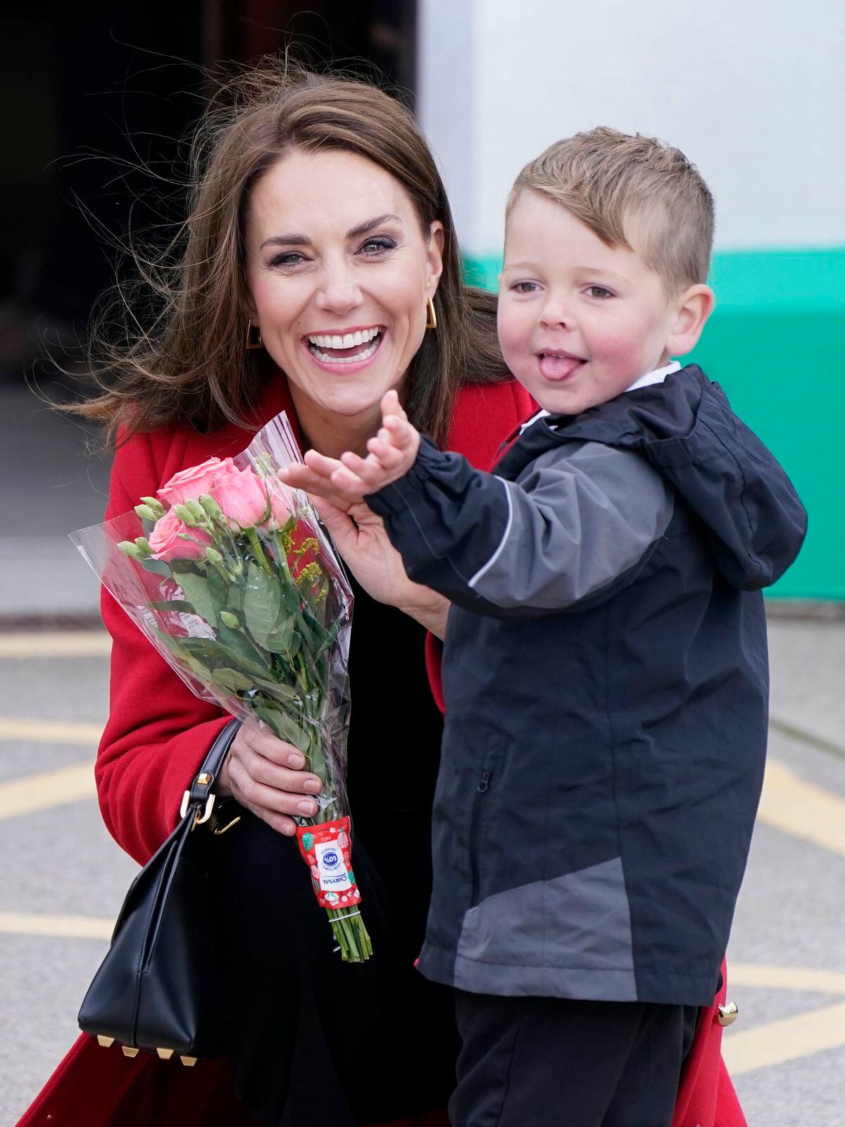 The Princess of Wales receives a posy of flowers from four-year-old Theo Crompton as she arrives for a visit to the RNLI Holyhead Lifeboat Station. 