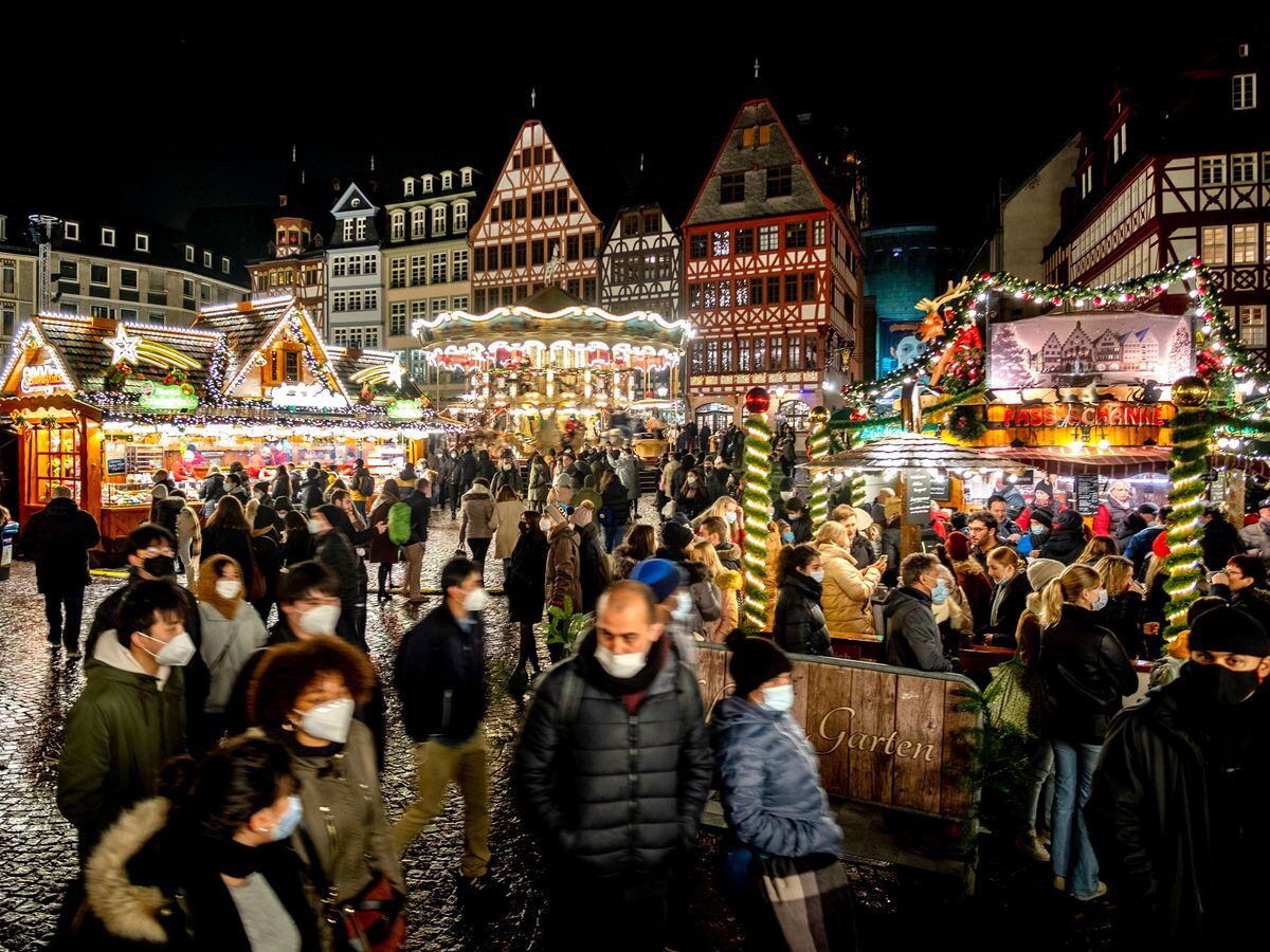 People wear face masks as they visit the traditional Christmas market in Frankfurt, Germany (Michael Probst/AP)