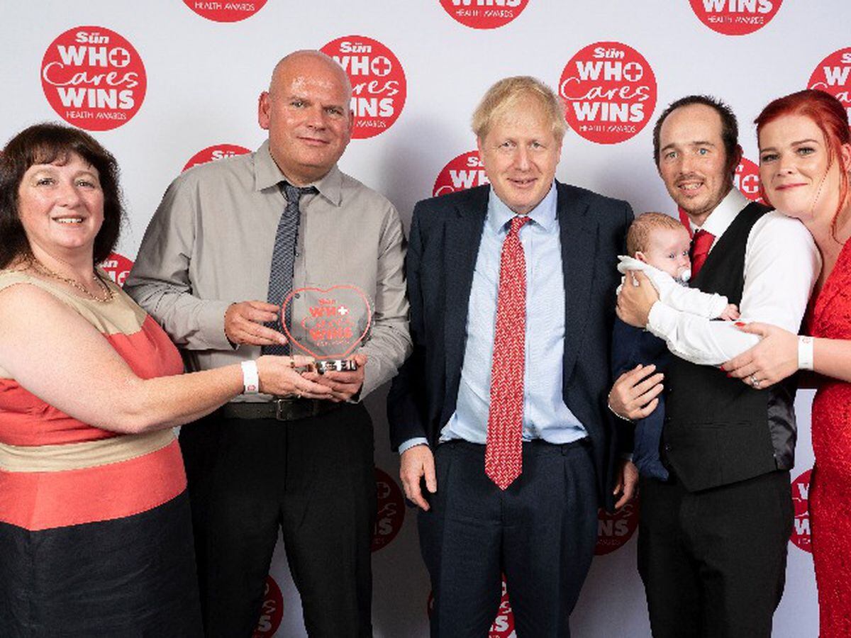 Prime Minister Boris Johnson stands alongside winners Nick Evans and Ruth Lowe, left, who were nominated by Sarah and Mike Clifford after saving their baby Logan. Photo: Dan Charity - The Sun.