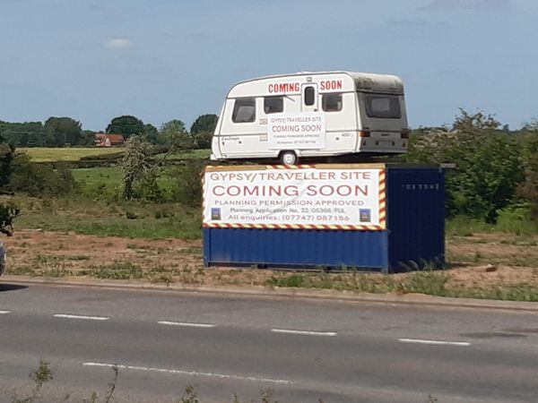 A caravan has been placed on top of a shipping container outside Market Drayton to advertise the arrival of a gypsy/traveller site