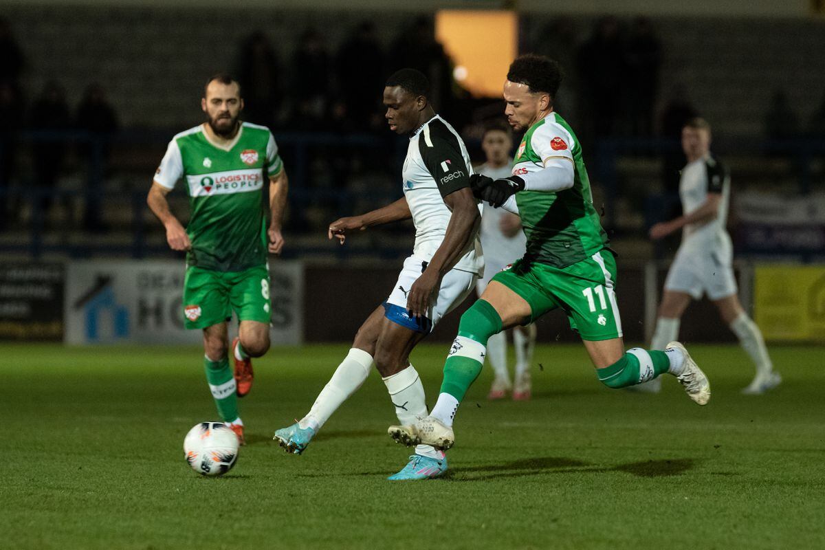 Prince Ekpolo (14) (AFC Telford United Midfielder) coming through midfield about to pass out to the wing while being pressured by Kettering Rhys Sharp