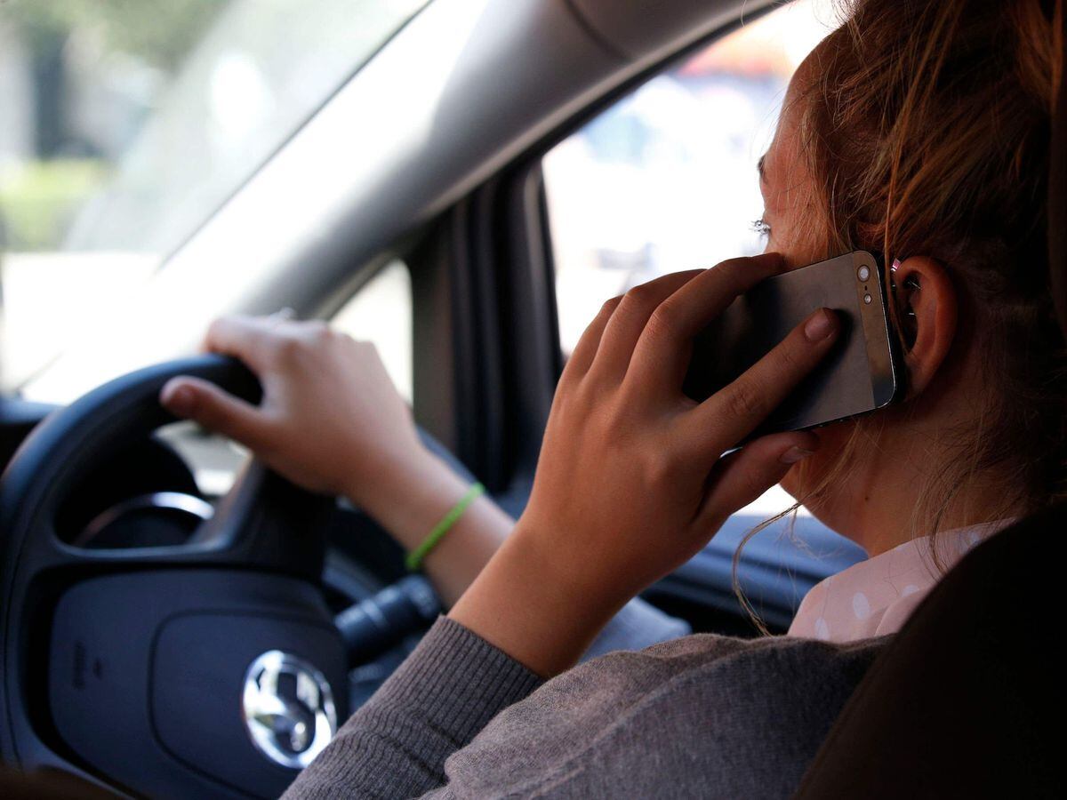 A woman talking on her phone whilst driving