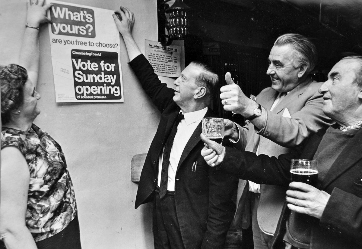 Customers of the Golden Lion, Four Crosses, give the thumbs up as landlord Les Broome puts up a poster in support of Sunday pub opening in October 1968. Welsh local authority areas held a referendum a few weeks later on whether to allow Sunday pub opening, and Montgomeryshire switched to going "wet," so those Golden Lion customers got their wish of Sunday drinking.