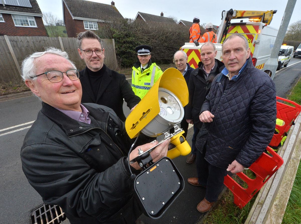 Councillor Roger Evans holds one of the new cameras near where it is being installed in Hanwood