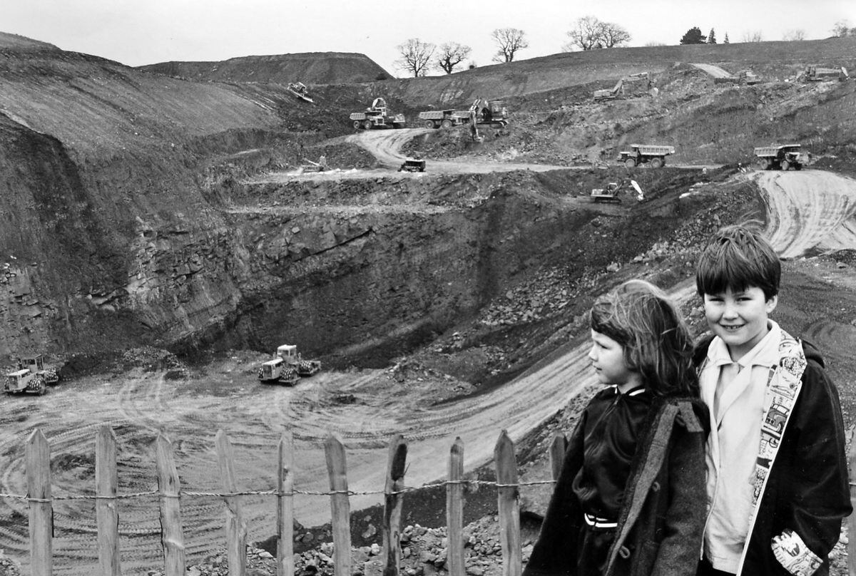 Chirk residents were treated to a look behind the scenes at British Coal's Ley Farm opencast mine in April 1988, when the operation on the 86 acre site, part of which was along the line of the new Chirk bypass, was being run down. Clare Grimley, five, and Tanya Wilson, nine, watch the giant machinery at work.