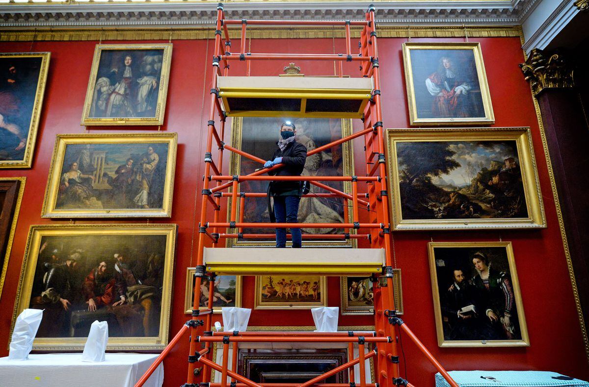 Collections assistant Holly Kirby, carefully cleans the artwork in the picture gallery at Attingham Park mansion.
