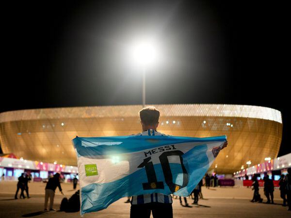 A man holds an Argentinian flag prior to the World Cup quarterfinal soccer match between the Netherlands and Argentina, outside the Lusail Stadium in Lusail, Qatar, Friday, Dec. 9, 2022.