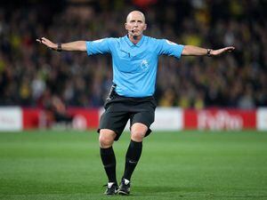 Mike Dean referees a Premier League game