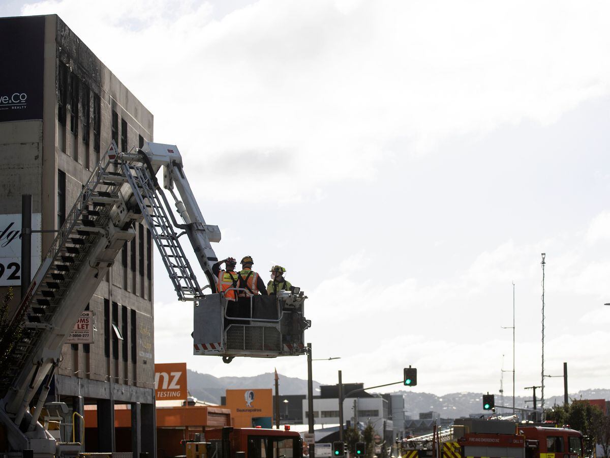 Investigators survey the scene after a fire at Loafers Lodge in Wellington, New Zealand