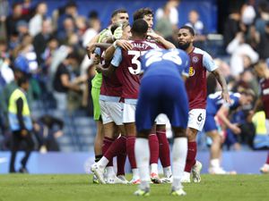               Chelsea's Levi Colwill looks dejected as Aston Villa players celebrate behind after the final whistle