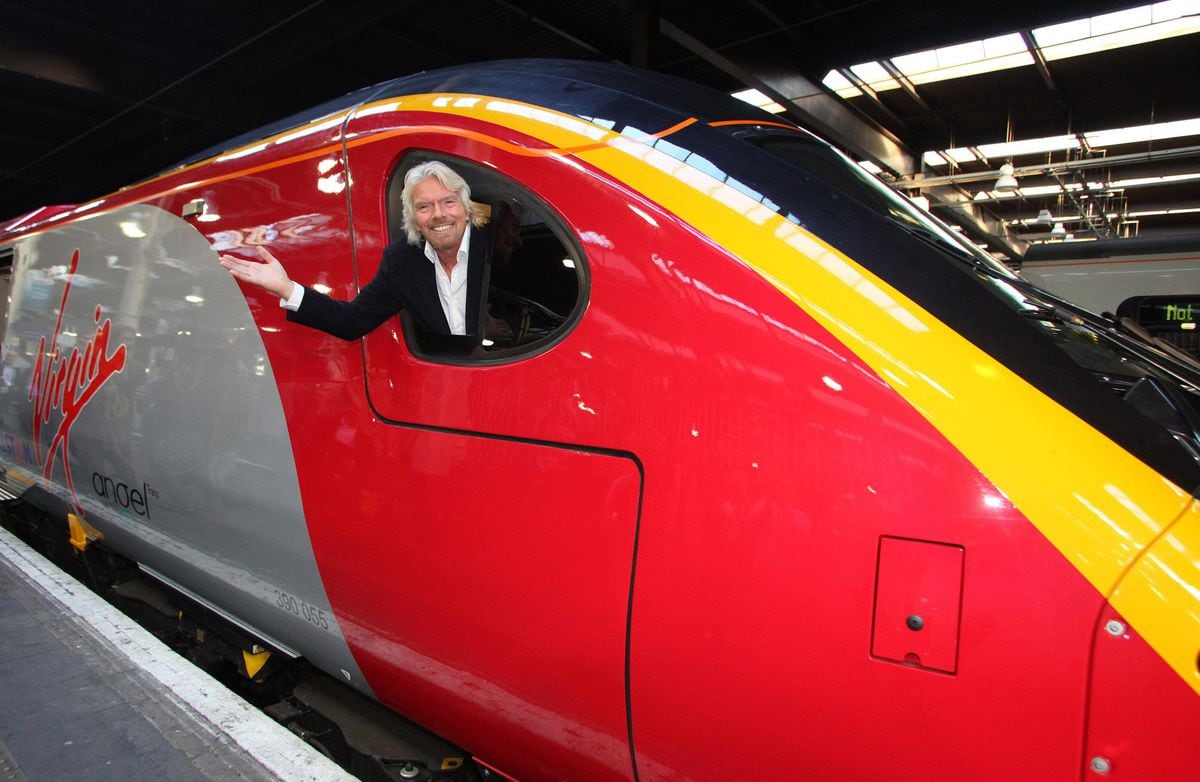 Sir Richard Branson at the window of an 11 carriage Pendolino train at Euston railway station in central London as Virgin Trains is celebrating record numbers of customers this year with the company on track to move 30 million by the end of December 2011.  PRESS ASSOCIATION Photo.  Picture date: Wednesday  December 7, 2011. The train pictured is currently undergoing tests and should be into service with Virgin Trains next year. Photo credit should read: Geoff Caddick/PA Wire . 
