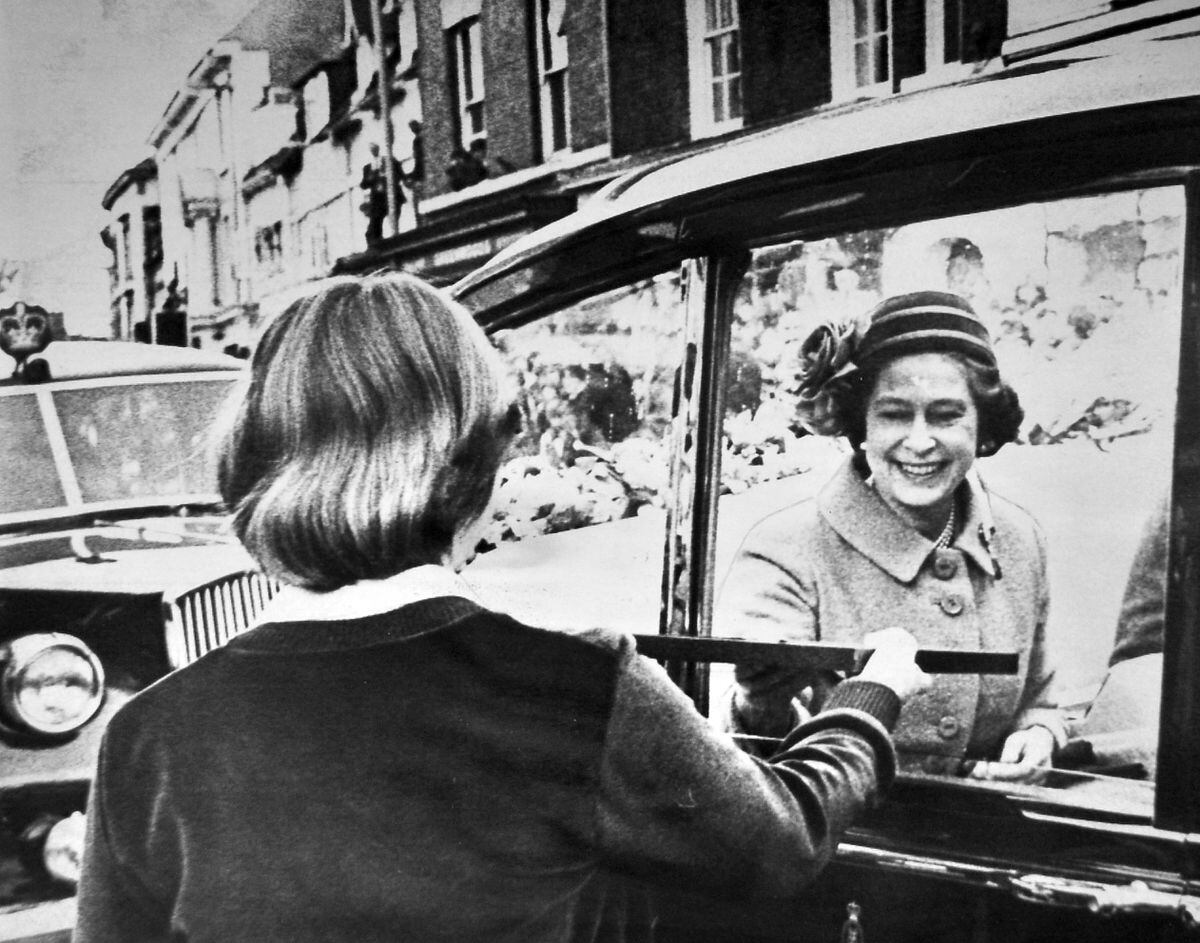 The Queen stops briefly at The Butter Cross, Newport, and is given a framed print by Julie Harrison of Burton Borough School during her visit to Telford in 1981