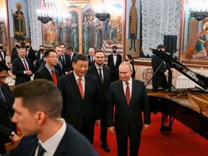 Chinese president Xi Jinping, centre left, and Russian president Vladimir Putin, right, walk after their dinner at The Palace of the Facets in the Moscow Kremlin in Russia