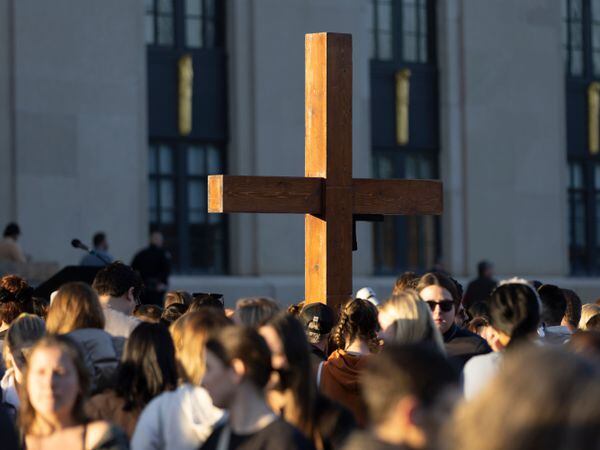 A cross stands above the crowd during a vigil held for victims of The Covenant School shooting on Wednesday, March 29, 2023, in Nashville, Tenn