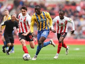 Daniel Udoh of Shrewsbury Town gets away from Luke O'Nien and Jay Matete.