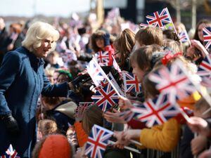 Queen Consort Camilla is greeted by flag-waving crowds in Southwater
