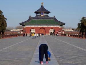 A man walks on all four limbs as a form of exercise in the Temple of Heaven park in Beijing