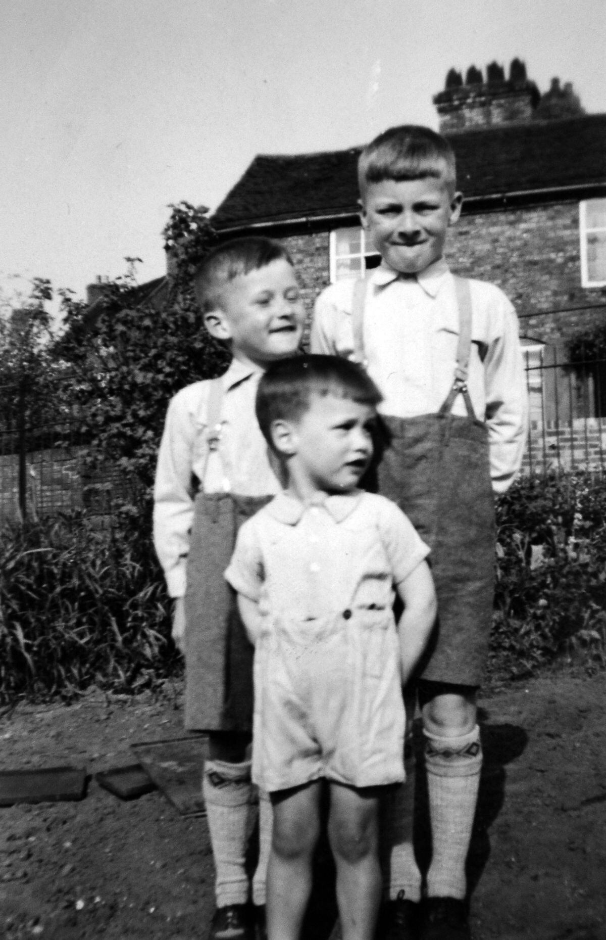 Young Alan, front, with his brothers Arthur and Ted outside their home in Carpenters Row, Coalbrookdale – a row which was condemned, but ironically is now a cherished heritage asset for the Ironbridge Gorge.