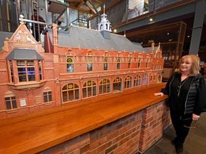 Jackie Tonry, staff member at Ludlow Brewing Company, views the impressive model of the old Ludlow Town Hall, made by David Jackman
