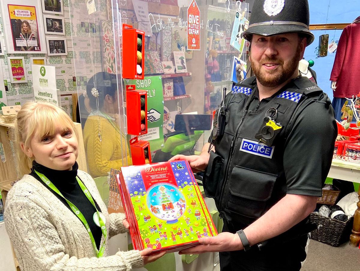 PC Kerry hands back the stolen advent calendars at the Oxfam shop in Wellington. Photo @ShropCop.