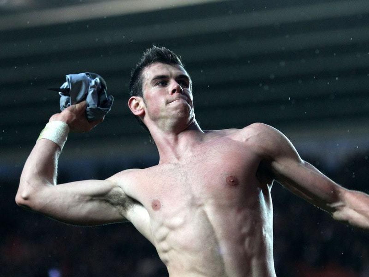 Soccer star Gareth Bale displays his muscular physique as he throws his shi...