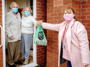 Volunteer Kim Wootton helps out residents John and Joyce Hinton with shopping deliveries