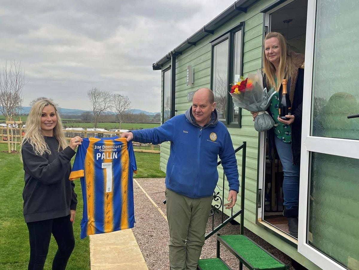 Trevor and Tina Palin are presented with a signed Shrewsbury Town football shirt by Spring Lea Holiday Park and Fishery manager Alison Naughton after receiving the key to their new caravan holiday home.