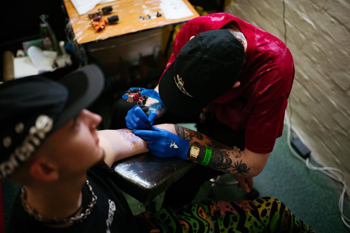 Tattooist Stevie Postle working on John Wynn inside a cell