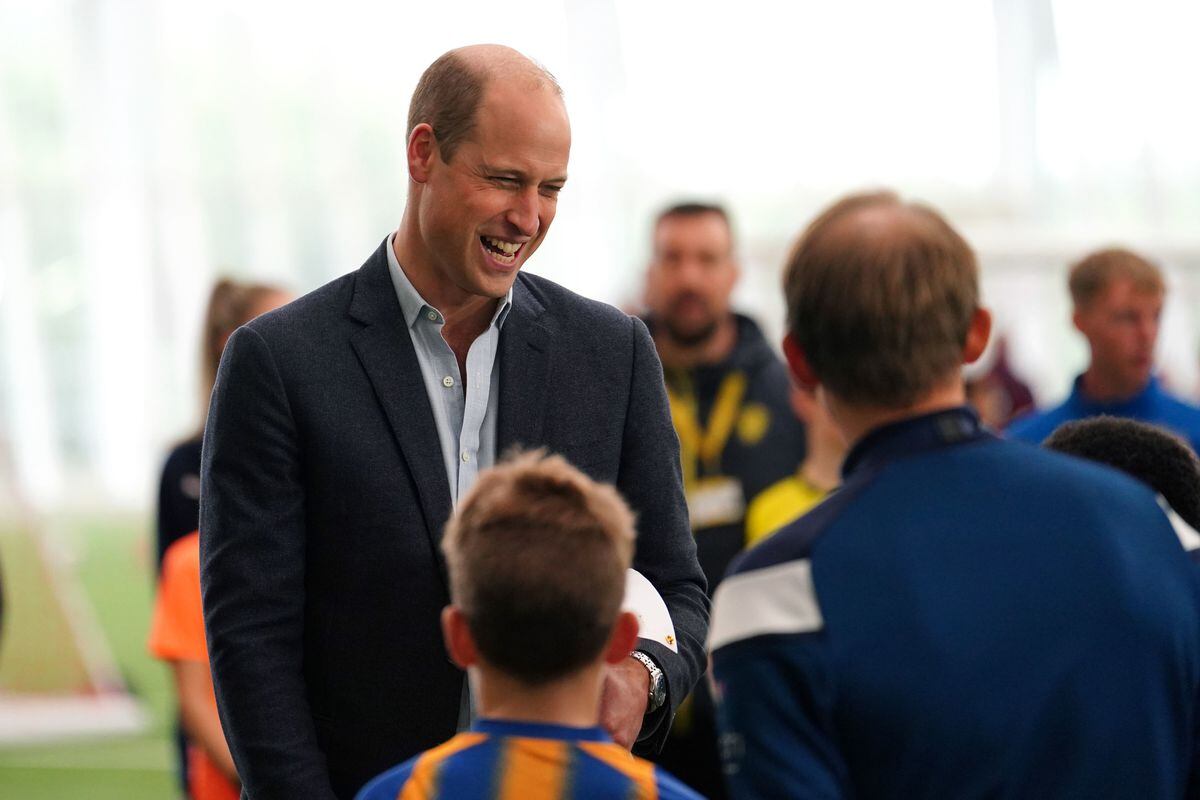 The Prince of Wales talks to youngsters in Shrewsbury Town shirts during his visit to St George's Park