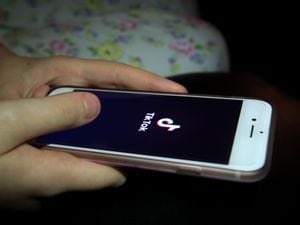 A young girl uses TikTok on a smartphone