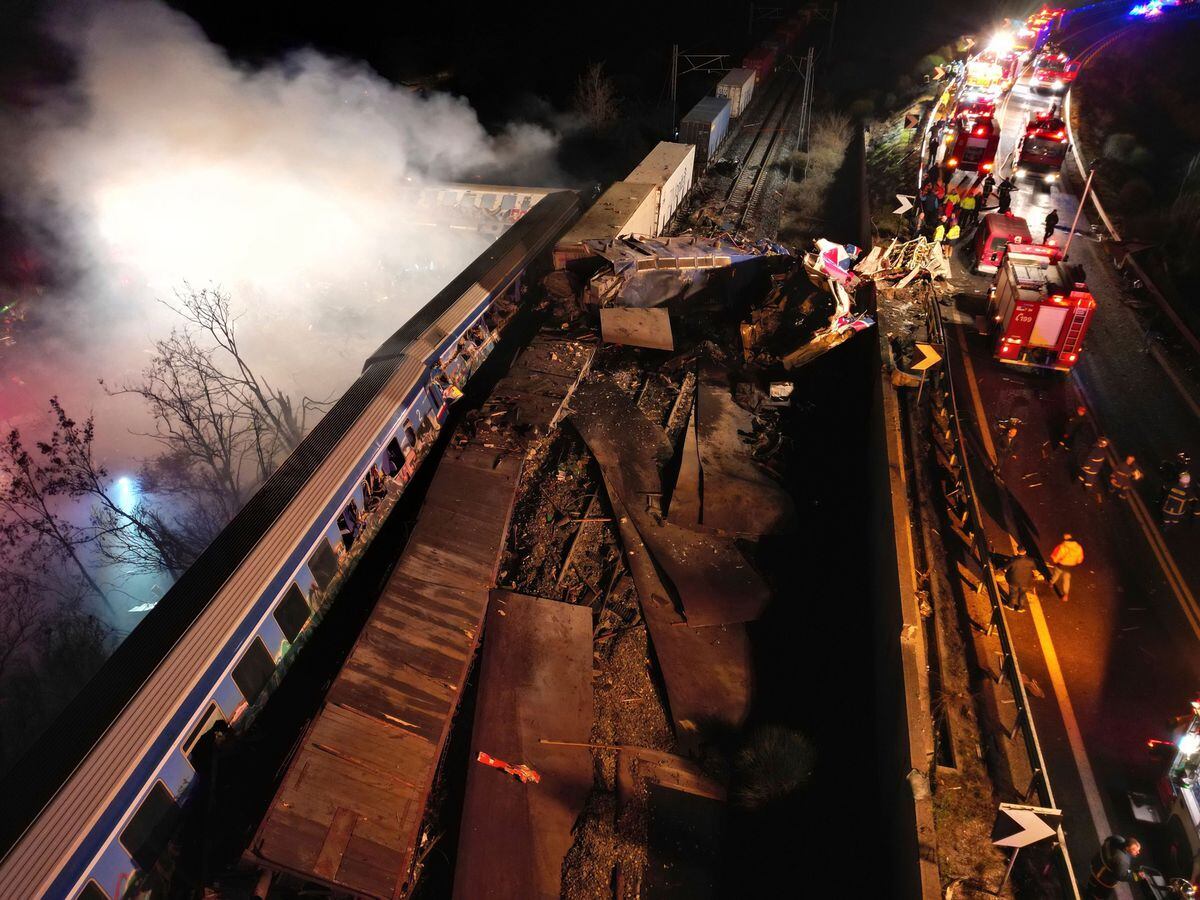 Smoke rises from trains as firefighters and rescuers operate after a collision near Larissa city, Greece, early Wednesday, March 1, 2023. The collision between a freight and passenger train occurred near Tempe, some 380 kilometers (235 miles) north of Athens, and resulted in the derailment of several train cars