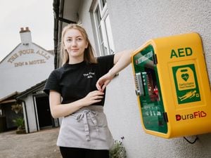 Staff member Amelia Fleet with the defibrillator at The Four Alls Inn