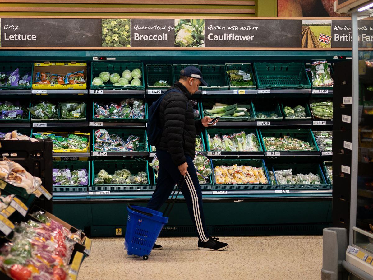 A man in the vegetables section of a supermarket