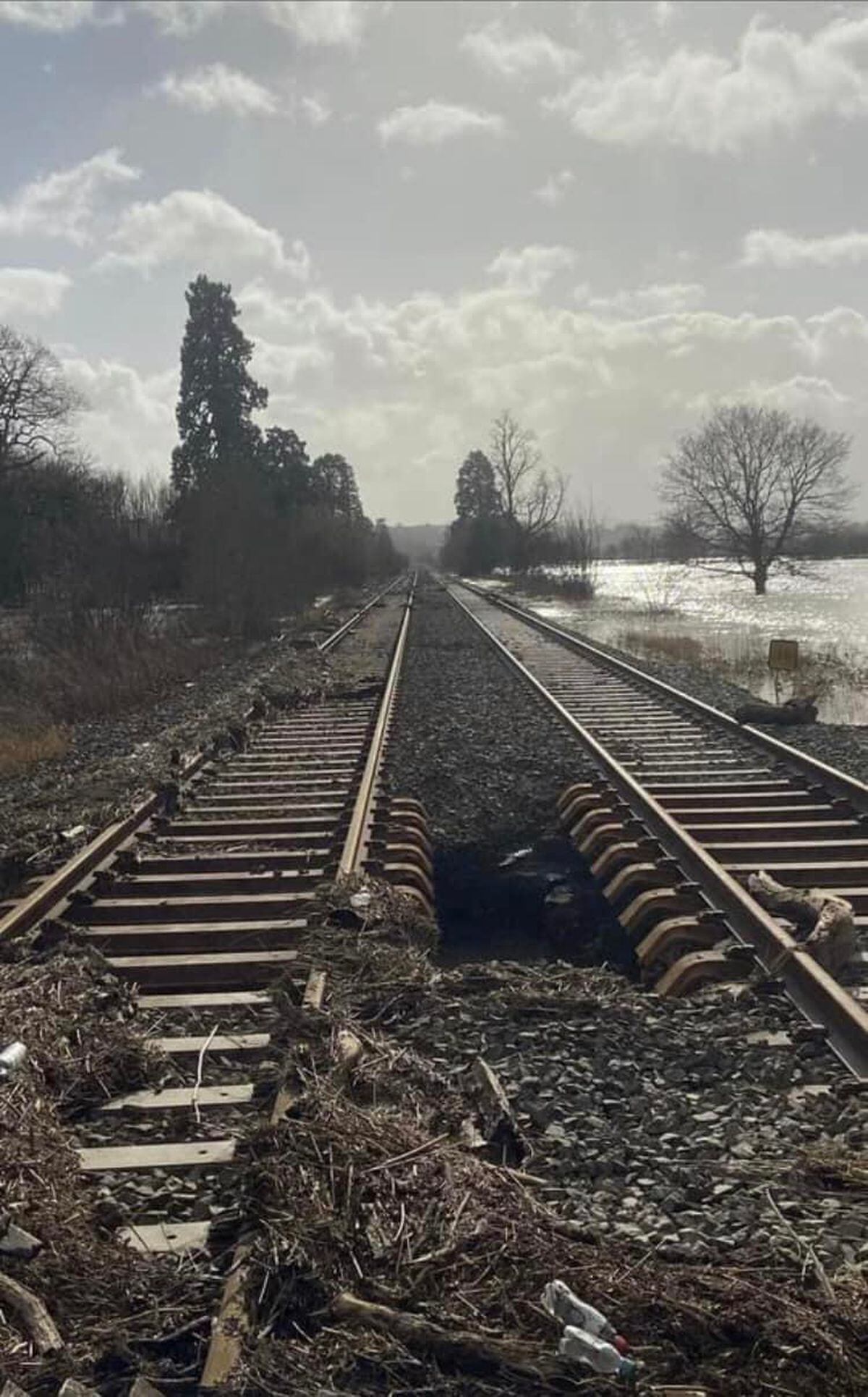 A section of railway track just outside Welshpool Railway station where the earth was washed away by flood water