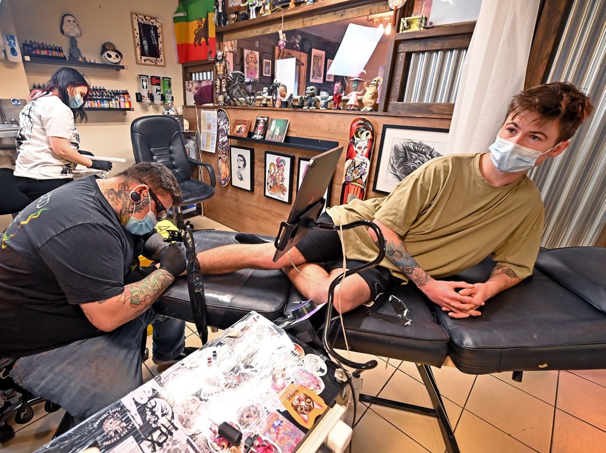 Josh Jones receiving a tattoo on his ankle