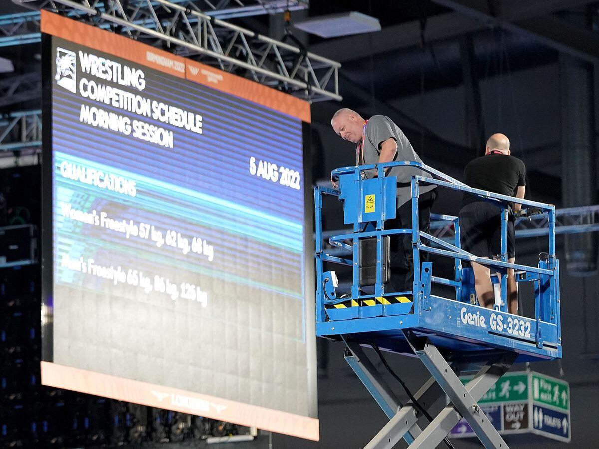 Staff carry out safety checks at the Coventry Arena after a speaker cover fell from the roof at Friday morning's wrestling session, forcing a delay in the action