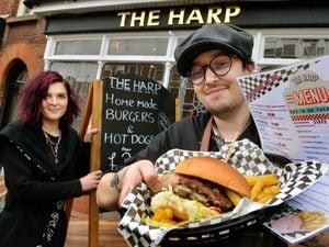 Chef Tom Knowles at the Harp shows off their burgers to beat McDonald's with staff member Rebecca Scott 