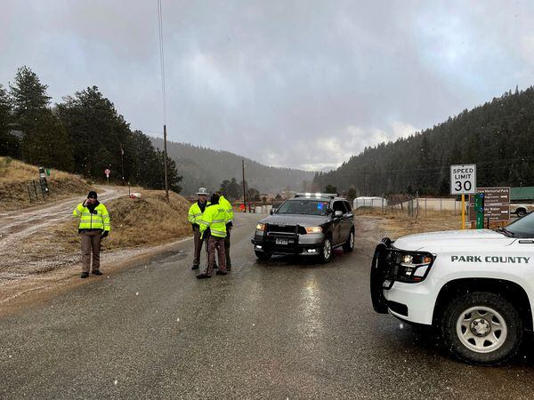 Authorities block a road in the town of Bailey, Colorado, where authorities found an abandoned car belonging to the suspect in a shooting of two administrators at a Denver school