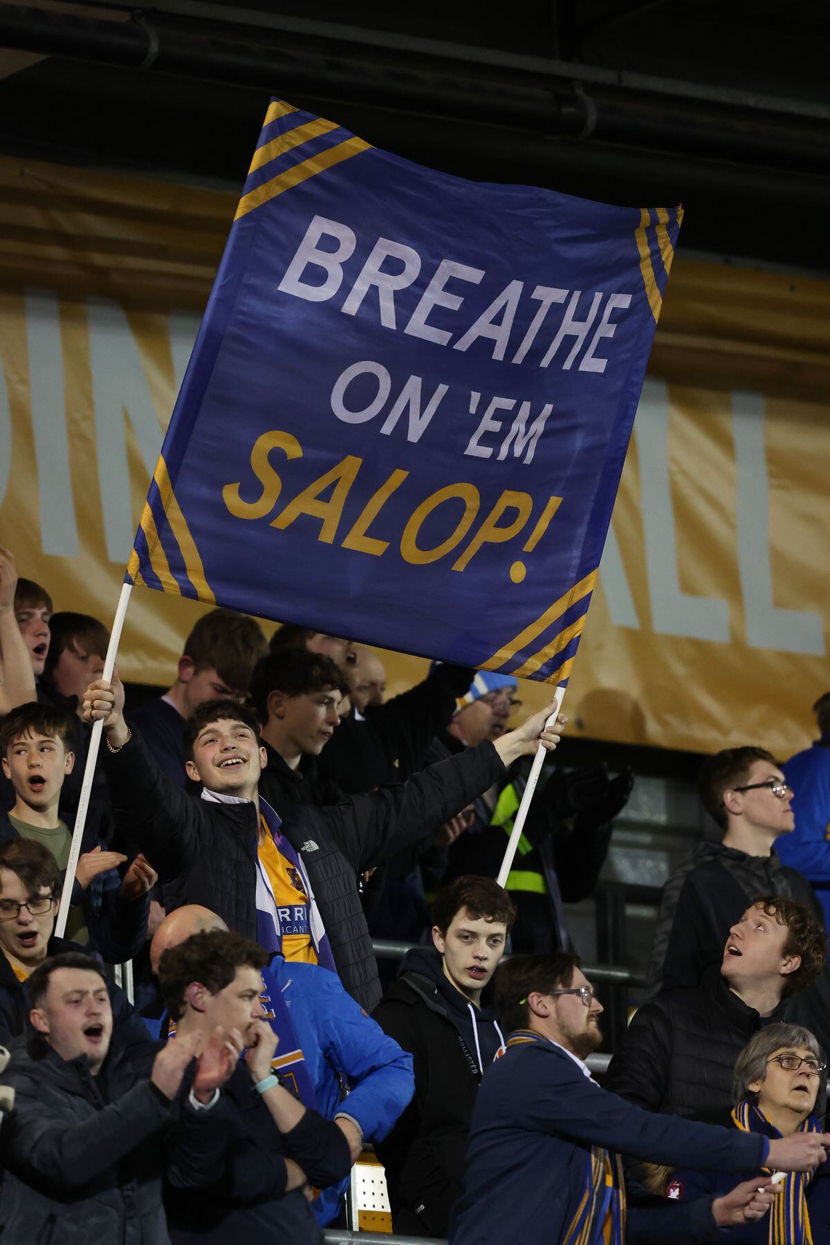 Shrewsbury Town fans hold flags in the South Stand. (AMA)