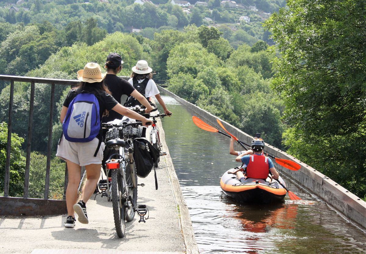 Cyclists and a kayaker cross the aqueduct