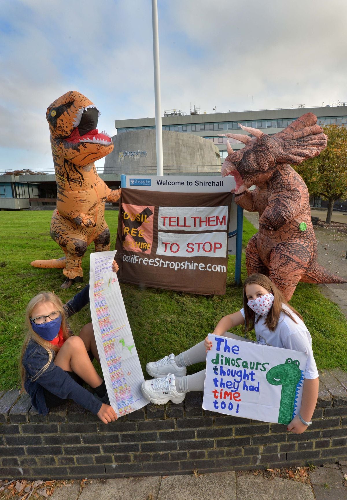 Youngsters Alice Russell 9, and Ana Russell 9, were joined by dinosaurs to hand in a petition asking the council to think about their investments into fossil fuel companies.