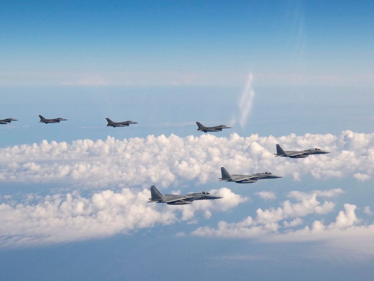 Three F-15 warplanes of the Japanese self-defence force, front, and four F-16 fighters of the US armed forces fly over the Sea of Japan